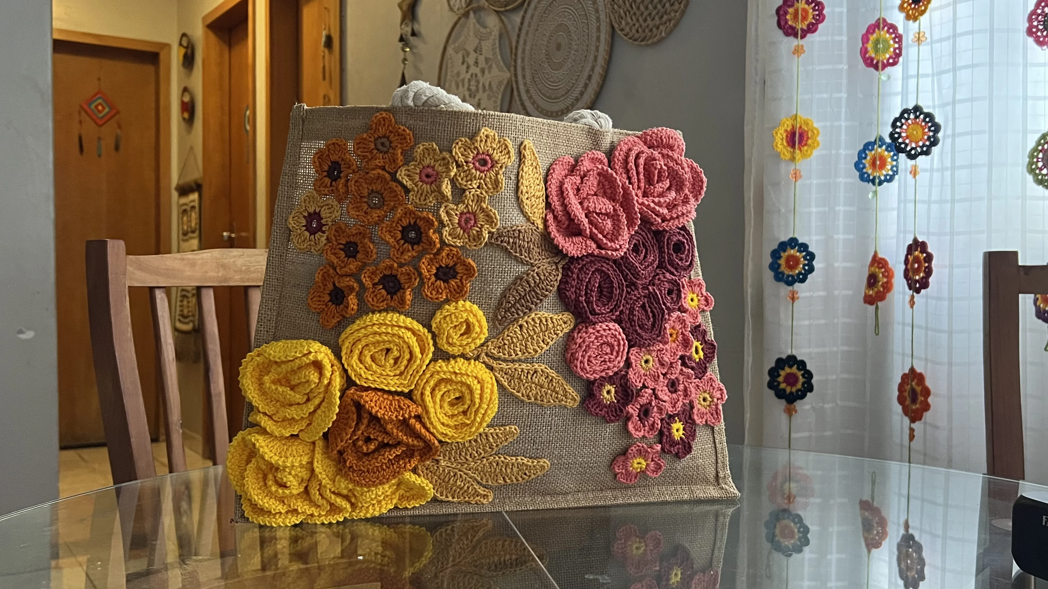 Bolsa sobre mesa - composição com cortina de flores ao fundo