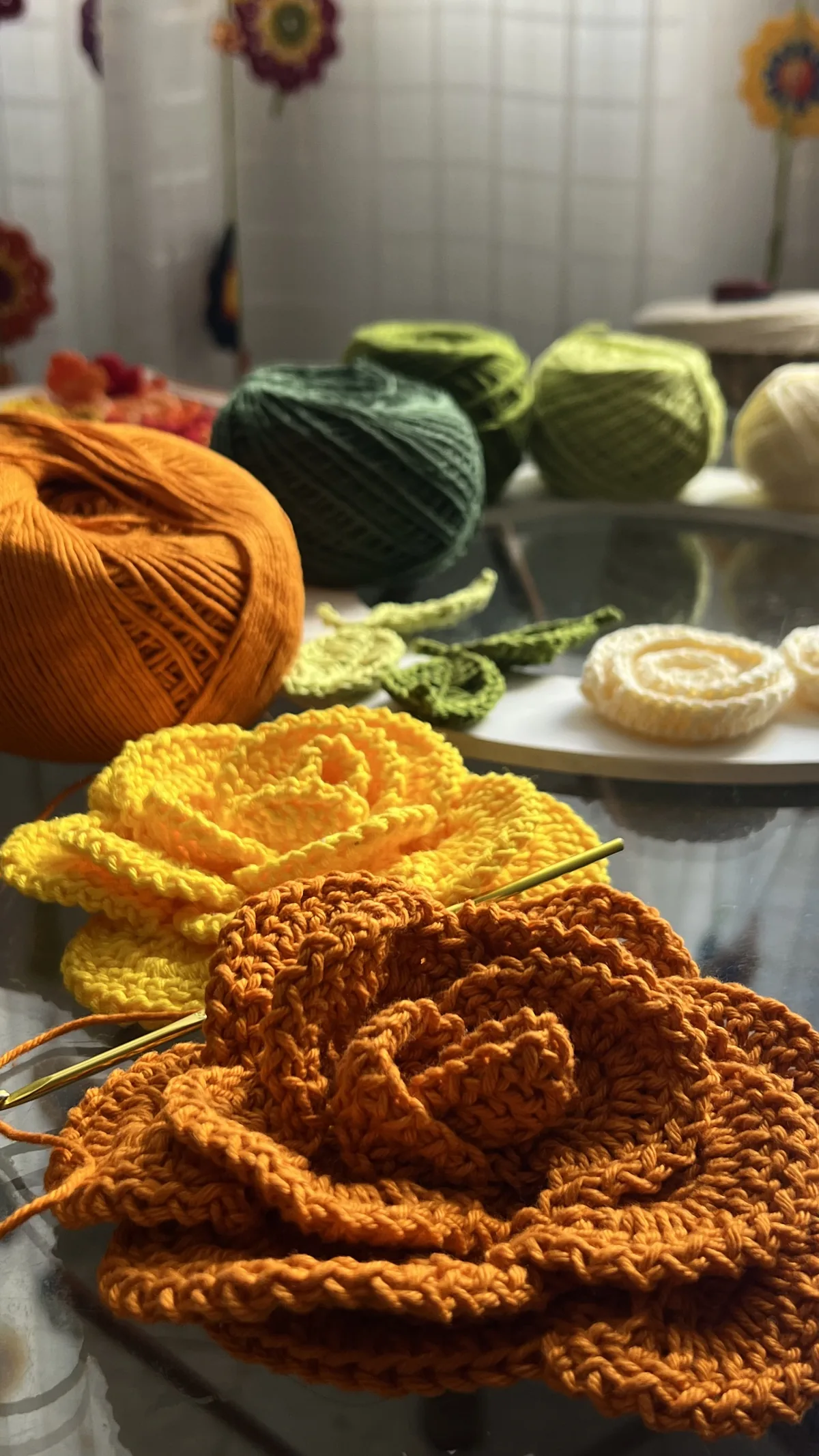 Novelos de linha coloridos e Flores Regina em crochê laranja e amarelo